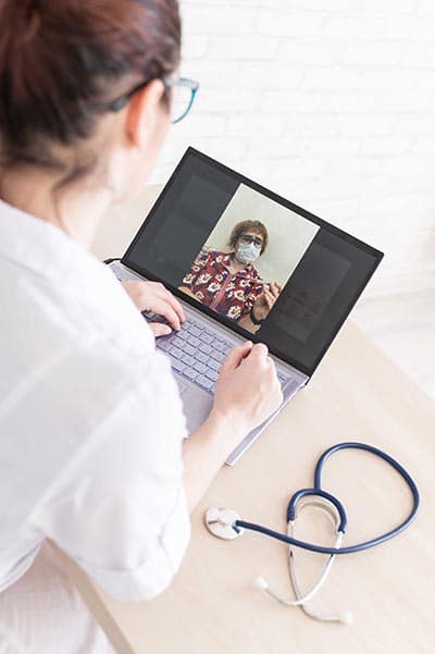 Une femme faisant une téléconsultation sur un ordinateur portable,