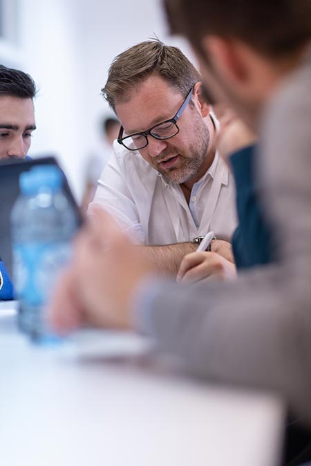 Reunion de 4 hommes autour d'une table, un ordinateur portable au premier plan